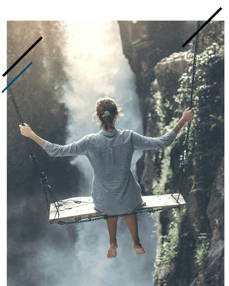 Woman on a large swing by a waterfall